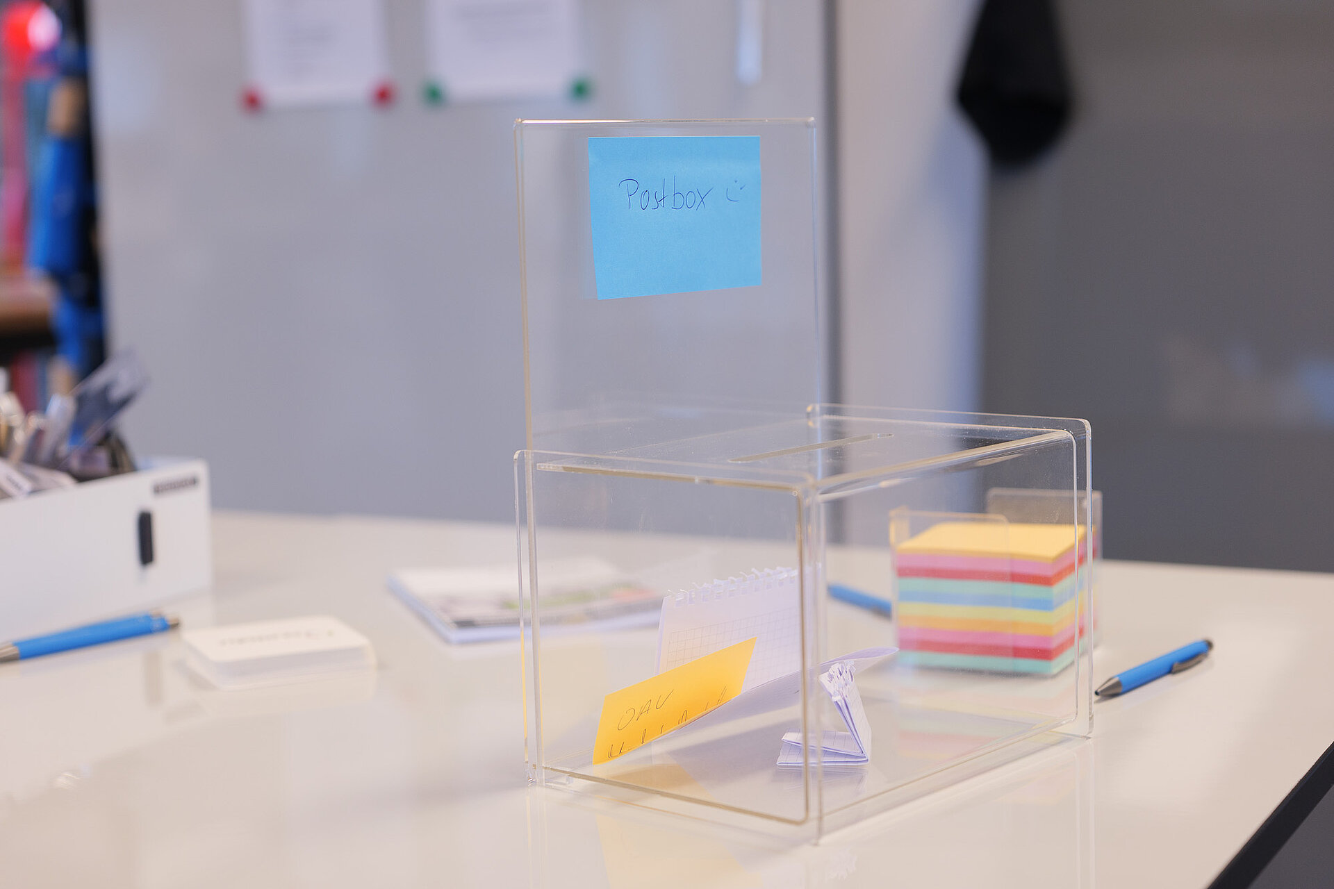 Eine transparente Box, in der Zettel mit Kundenfeedback und Ideen gesammelt werden